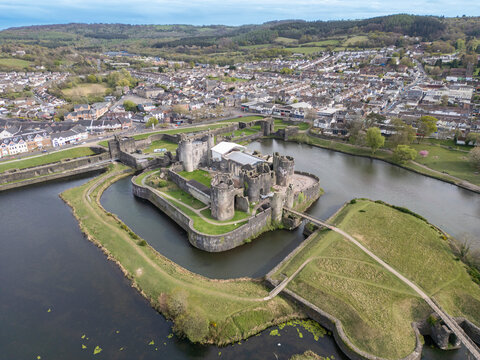 Aerial view of caerphilly castle surrounded by a scenic moat and lush greenery, bryncenydd, wales, united kingdom.