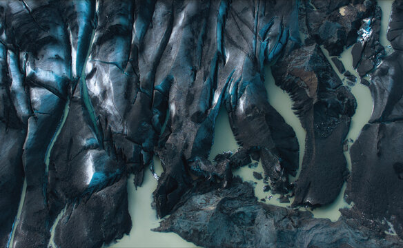 Aerial view of majestic glacier tongue with beautiful blue ice and serene water, H^fn, Southern Region, Iceland.