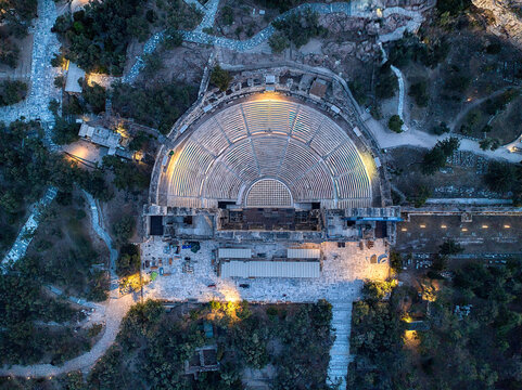 Aerial view of the historic Odeon of Herodes Atticus amphitheater illuminated at night, Athens, Attica, Greece.
