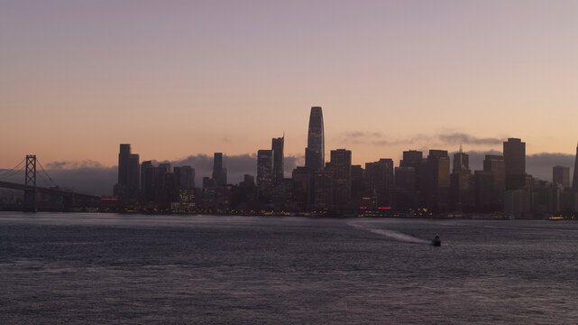 Aerial view of stunning sunset skyline with towering skyscrapers and the iconic Bay Bridge, Financial District, San Francisco, California, United States. - Powered by Adobe