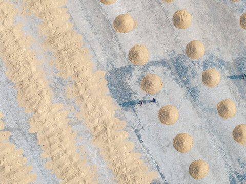 Aerial view of rice mill with drying heaps and patterns in agricultural field, Dhaka, Dhaka, Bangladesh.