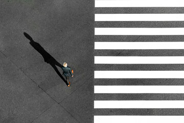 Tokyo City, Japan - 16 November 2020: Aerial view of zebra crossing with black and white stripes and a man in suit crossing, tokyo city, tokyo prefecture, japan.