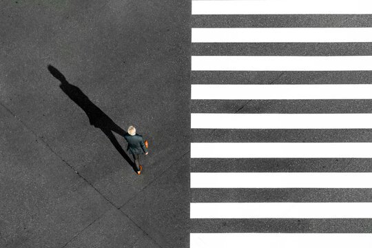 Fototapeta Tokyo City, Japan - 16 November 2020: Aerial view of zebra crossing with black and white stripes and a man in suit crossing, tokyo city, tokyo prefecture, japan.