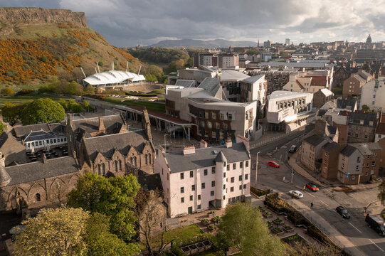 Aerial view of the beautiful Scottish Parliament surrounded by historic architecture and lush greenery with Salisbury Crags and Physic Garden, Holyrood, Midlothian, Scotland.