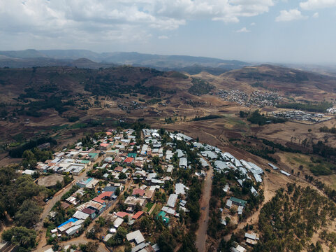 Aerial view of a picturesque rural village with scenic hills and rooftops in a tranquil valley, Debre Birhan, Amhara, Ethiopia.