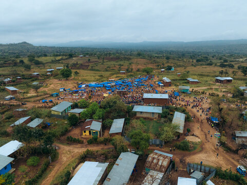 Aerial view of a vibrant tribal market in a rural village surrounded by greenery and hills, Kako, Southern Nations Nationalities and Peoples' Region, Ethiopia.