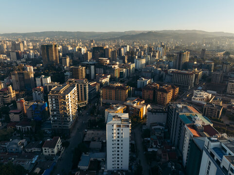 Aerial view of vibrant cityscape with modern skyscrapers and bustling streets at sunset, Addis Ababa, Ethiopia.