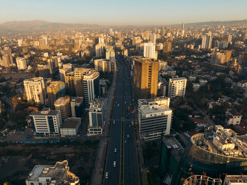 Aerial view of urban cityscape featuring modern buildings and a busy road at sunset, Bole, Addis Ababa, Ethiopia.
