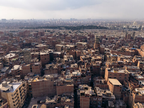 Aerial view of the bustling urban landscape of Mansheya Nasir, The Garbage City with crowded rooftops and dense buildings, Manshiyat Nasser, Cairo, Egypt.