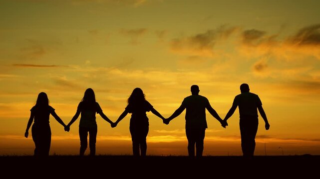 Unity of group of people united by team idea. Team of people look at their future together at sunset, park. Human resources. Group of business person outdoor. Community of people joint prayer, sunset
