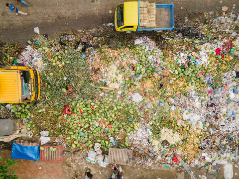 Aerial view of damaged watermelons among garbage and waste at a polluted landfill, Dhaka Kotwali Thana, Bangladesh.