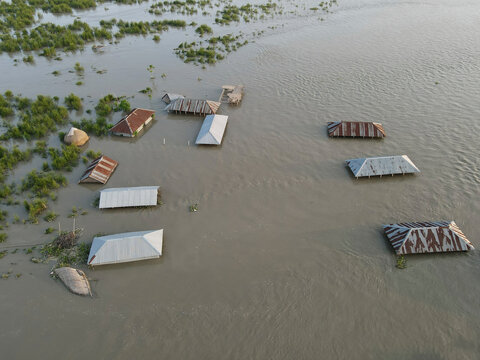 Aerial view of submerged houses and boats amidst flood water in a rural community, Jatrapur, Kurigram, Bangladesh.