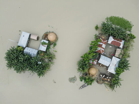 Aerial view of flood water surrounding homes and boats in a suburban landscape, Jatrapur, Kurigram, Bangladesh.