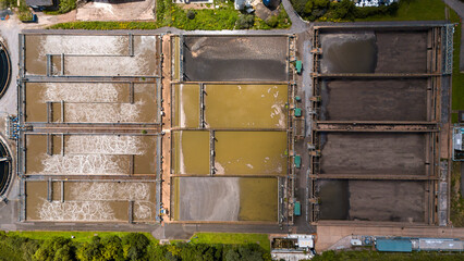 Aerial view of industrial water treatment facility with rectangular tanks and patterns, Exeter, England.