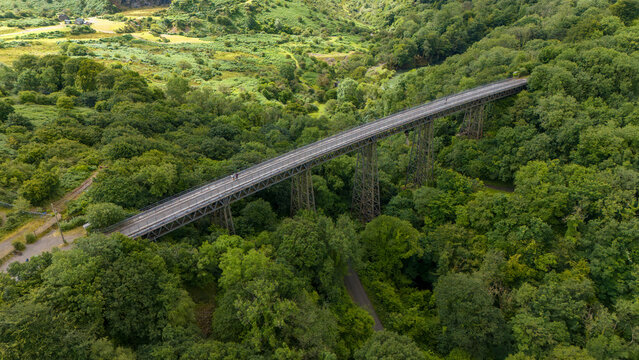 Aerial view of meldon viaduct surrounded by lush forest and trees, Okehampton, United Kingdom.