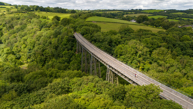 Aerial view of meldon viaduct surrounded by lush forest and tranquil hills, Okehampton, England.