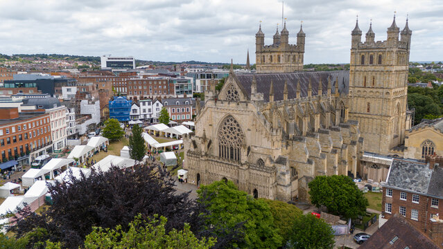 Aerial view of exeter cathedral and market surrounded by historic buildings and greenery, exeter, england.