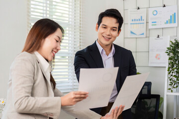 Obraz premium Financial Document Review. Business partners sharing insights on financial reports in an office.