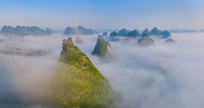 Aerial view of a lookout point terrace on the mountain top looking the Guilin mountain landscape at sunrise with low clouds, Guangxi, China.
