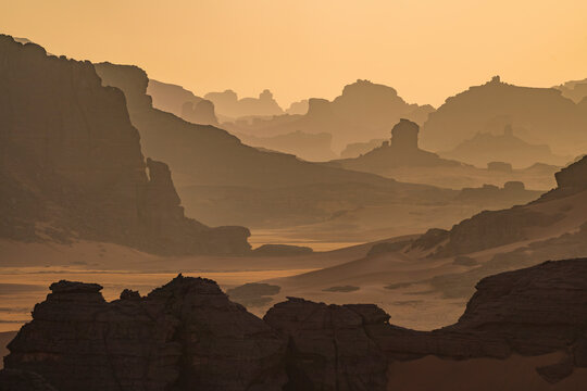 Aerial View of rock formations among sand dunes at sunset in the Sahara desert, Djanet, Algeria, Africa.