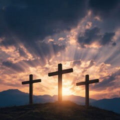 Three crosses stand silhouetted on a hilltop at sunset with sun rays shining through dramatic clouds in a spiritual landscape