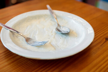 Blurred image,White plates and utensils that are filled with cheese sauce, white sauce from the spaghetti menu, topped with cheese sauce that girls eat with deliciousness and quickly disappeared.