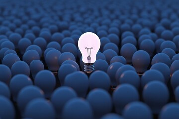 Unique lit light bulb amid many unlit light bulbs on a dark blue background