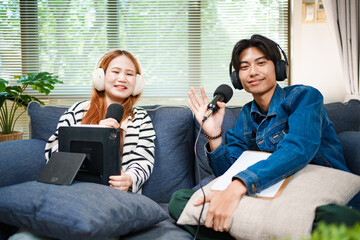 Friendly podcast hosts waving at camera with microphones and headphones