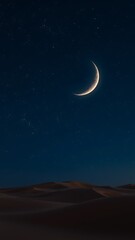 Crescent moon over serene desert landscape at night