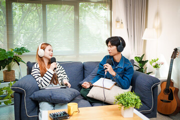 Two young people recording podcast at home with headphones and microphones