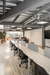 An organized office environment with multiple cubicles occupied by focused employees, demonstrating a productive and collaborative professional setting.

