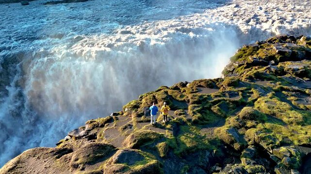 Witness the majestic Dettifoss waterfall cascading powerfully in Iceland, surrounded by rugged landscapes and vibrant green moss.