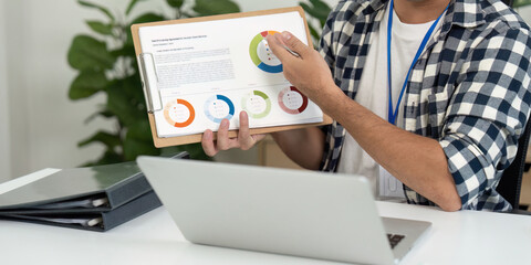 Data Presentation. Young man explaining charts during a business meeting in a home office.