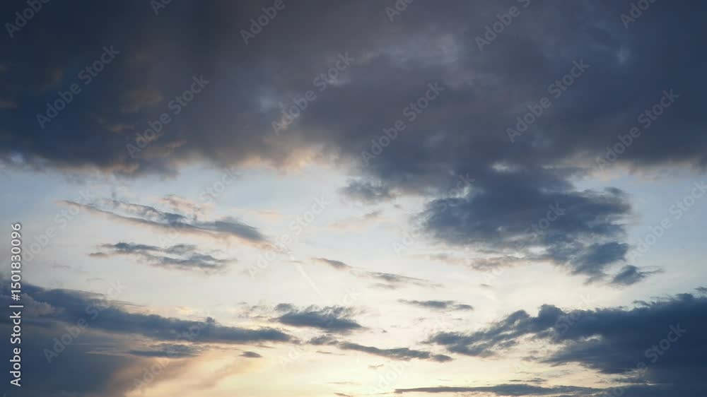 Poster Witness a breathtaking display of nature as the sky transforms with swirling clouds illuminated in warm hues. Rich blues and oranges blend perfectly during this enchanting evening moment.