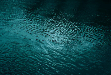 Ripples and reflection of light, blue green water surface background along with space for design