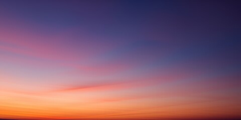 A gradient sky displaying a blend of orange, pink, and purple hues during twilight hours view
