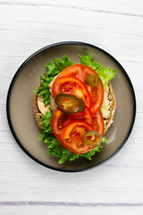 Sandwich with chiken and tomatoes on white table. Top view