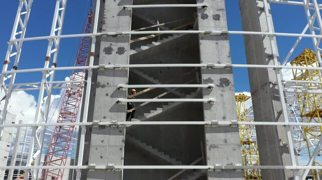 construction worker climbs concrete staircase construction site