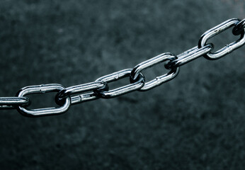 Fototapeta premium close-up of a metal chain link coil chain isolated against a blurred background with copy space. security, connected, or linked together design element.