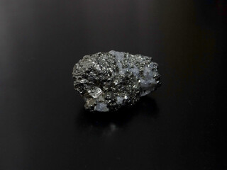 Close-up of a raw pyrite specimen with sharp cubic crystals, metallic luster on dark textured...