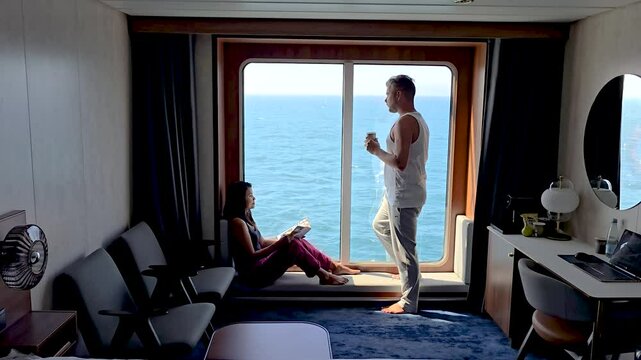 Enjoy a tranquil moment aboard a cruise ship with breathtaking ocean views of the Faroe Islands. A couple unwinds while sipping coffee and reading, surrounded by comfort and serenity.