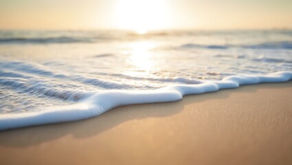 Soft ocean waves on sandy beach at sunrise