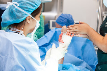 Hand surgery. Traumatology and orthopedics concept. Female doctor performing a surgery. Orthopedic surgeon. Surgery and insurance concept.