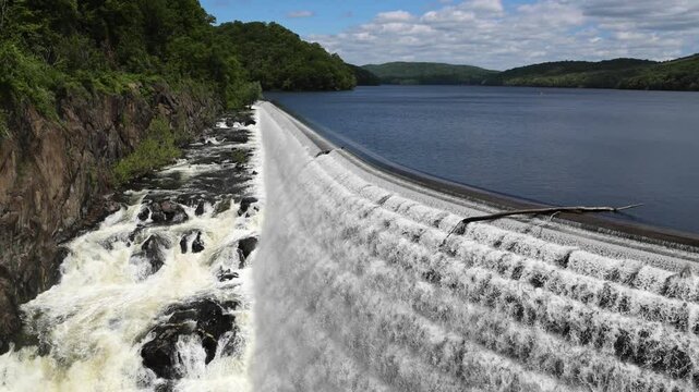 water cascading down waterfall at croton dam (man made and natural drinking water reservoir) westchester new york landmark with old bridge (tourism travel hiking destination) nature landscape
