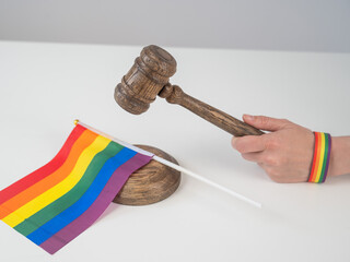 A judge slams a gavel on a rainbow flag.