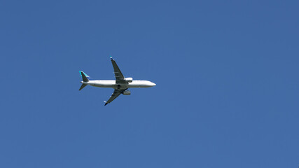 A white airplane is flying in the sky