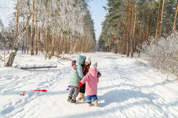 Naklejka premium Mother with children walking in nature in the winter forest