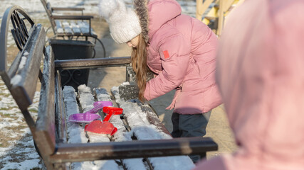 Two little girls playing on the playground on a winter day