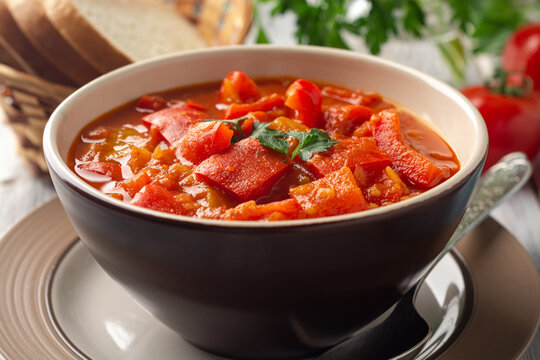 Traditional Hungarian dish lecho or Lecso or Letscho. Stew with peppers, tomatoes and onions in bowl on wooden background.