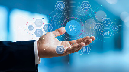Businessman reaches out to receive holographic data showing the workings of artificial intelligence (AI) and intelligently connected digital systems, representing data control, automation technology.